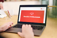 Symbolbild, aufgeklappter Laptop mit DRK Begrüßungsfenster