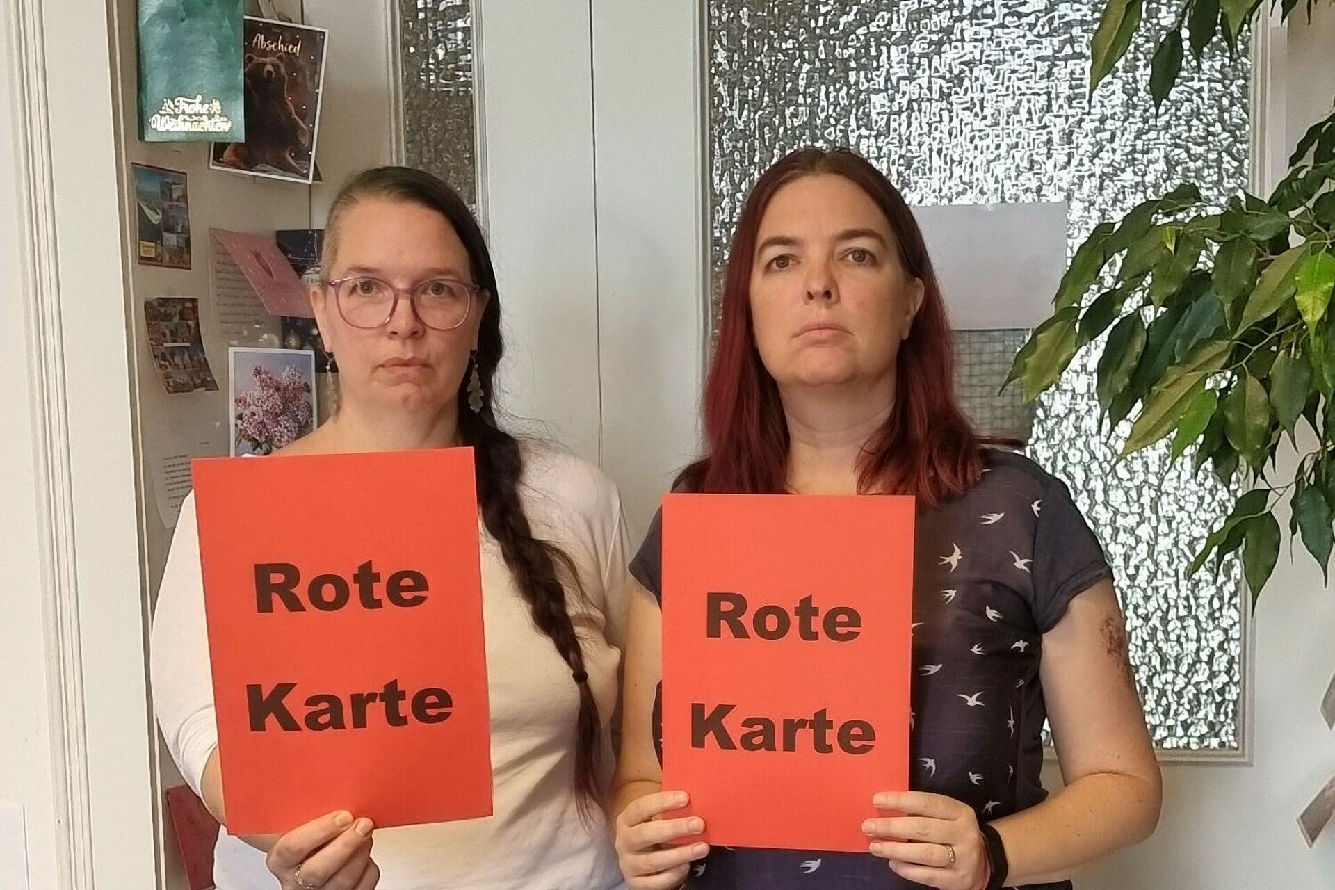 Die Leitungen der Sozialstation und Tagespflege stehen nebeneinander und zeigen eine rote Karte.